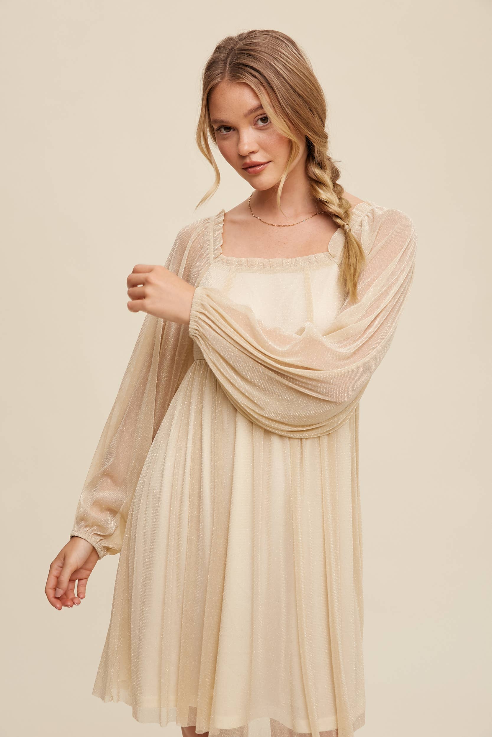 Model wearing a mauve shimmer mini dress with long sheer sleeves, square neckline, and flowy A-line silhouette — romantic sparkle party dress