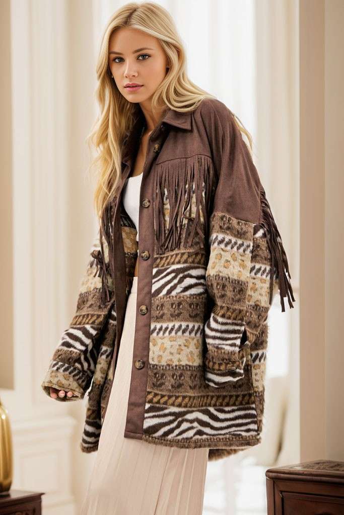 Brown Aztec print shacket with fringe detailing, button-front closure, and long sleeves, styled over a white strapless top and cream pleated pants.