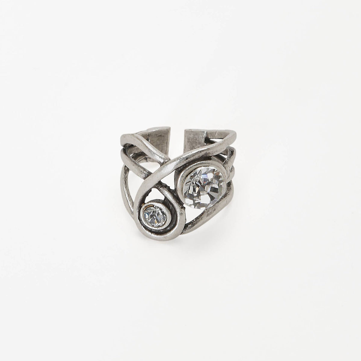 A silver-toned adjustable ring with a twisted wrap design, featuring a large round clear crystal and a smaller oval clear crystal, set against a plain white background.