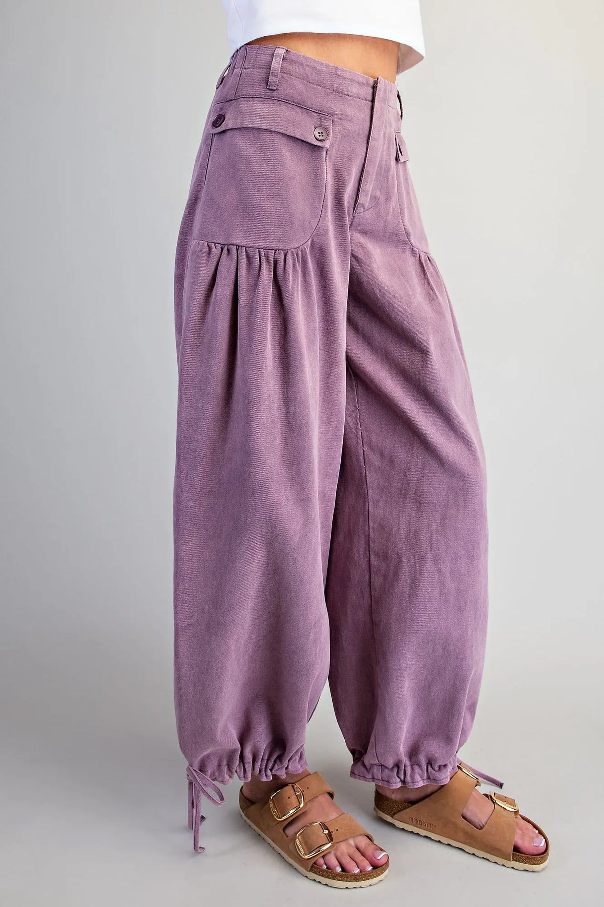 Side view of women's plum mineral washed tie cuff pants — high-rise waist with button pocket detail and gathered drawstring ankle cuff