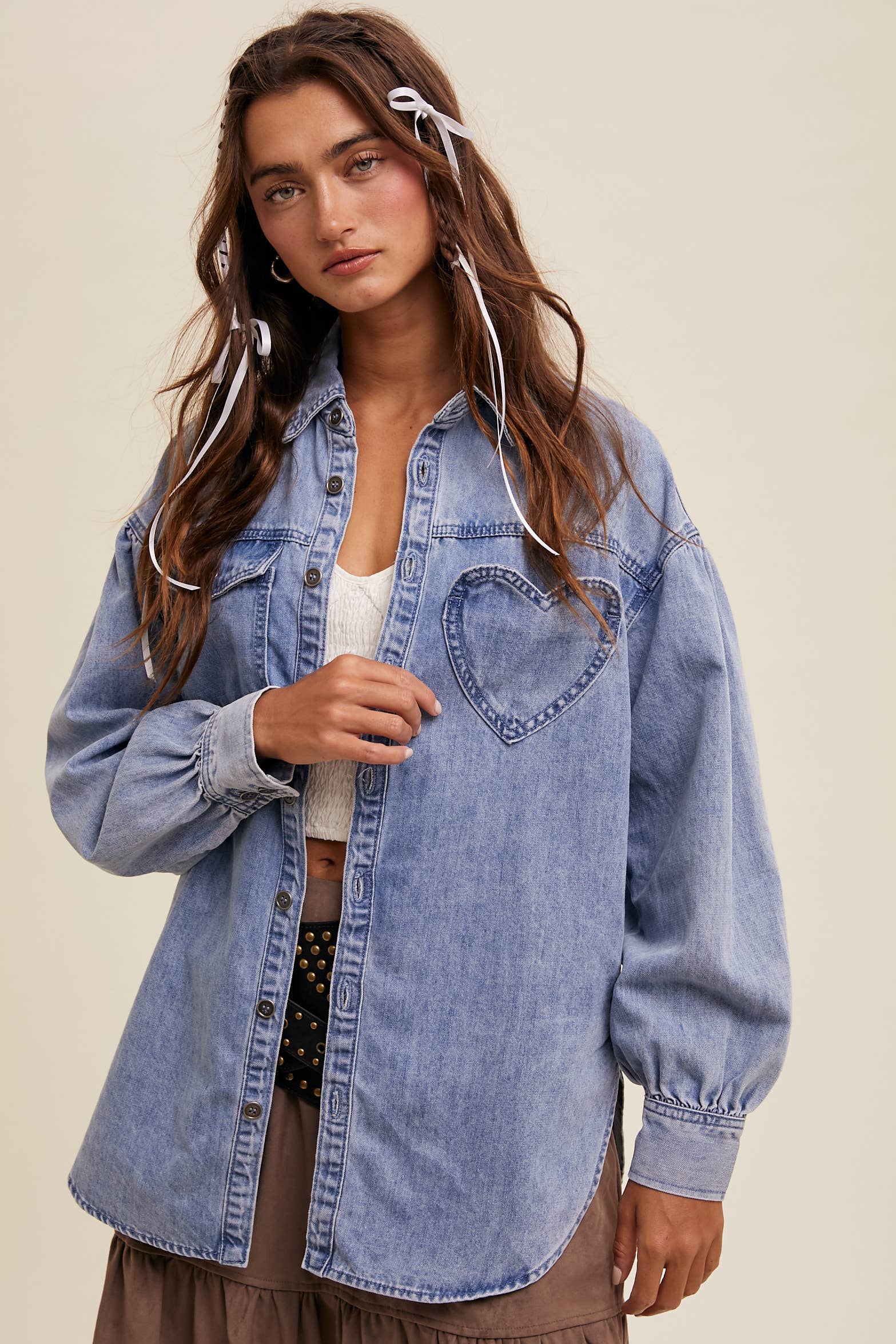 Light-wash oversized denim shacket with a heart-shaped chest pocket, button front, drop shoulders, balloon sleeves, and a curved hem.