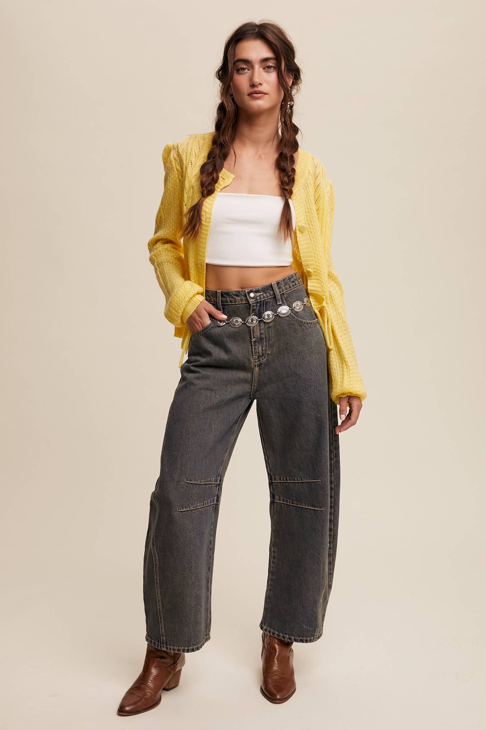 Dark wash wide-leg jeans with relaxed fit, seam detailing across the knees, and a high-rise waist, styled with brown ankle boots.