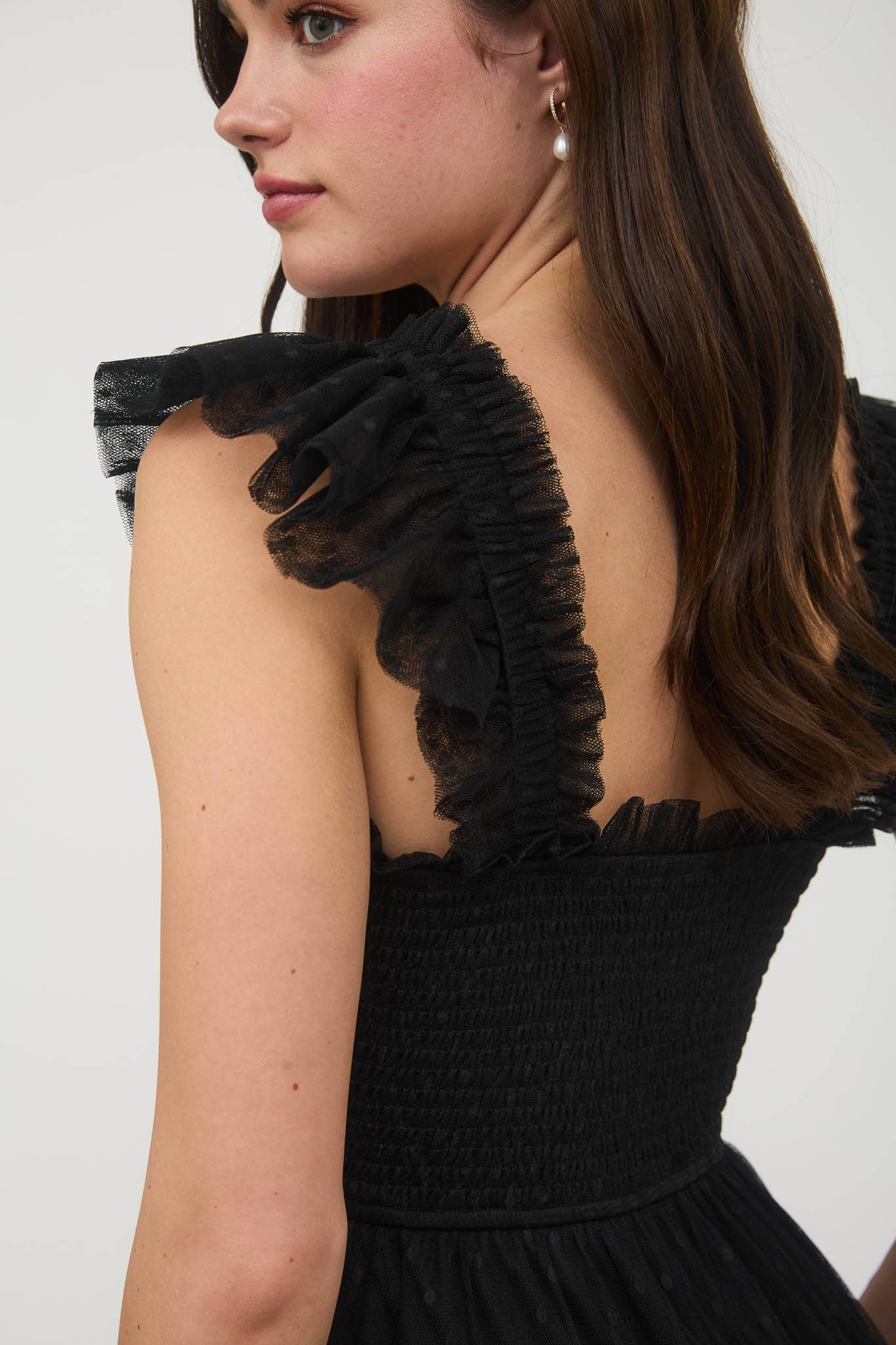 Black dress with ruffled details on a white background