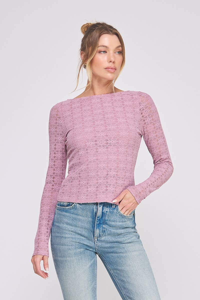 Woman wearing a orchid pink top and blue jeans against a white background