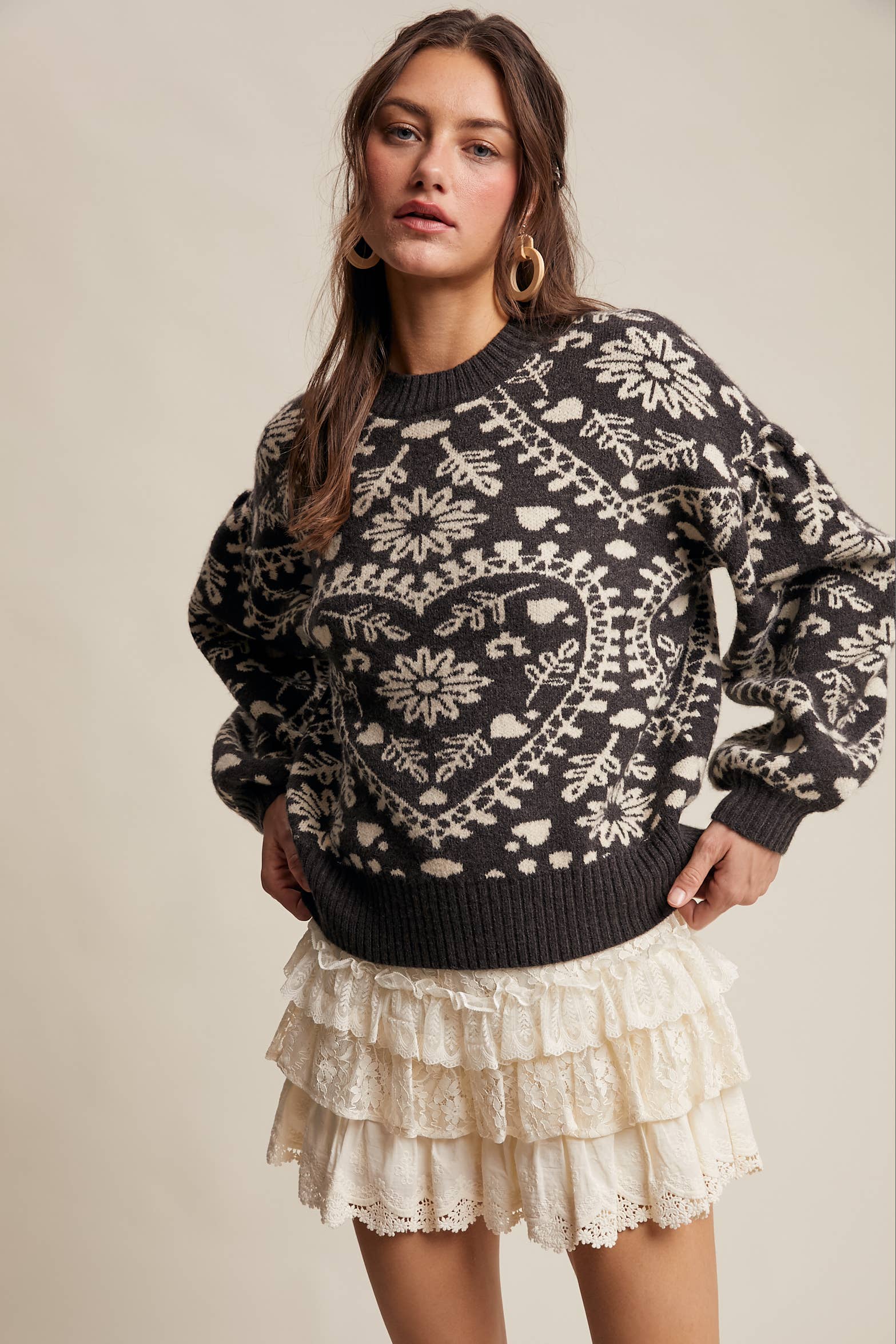 Charcoal crewneck sweater with cream floral heart–motif jacquard, puff sleeves, and ribbed cuffs and hem.