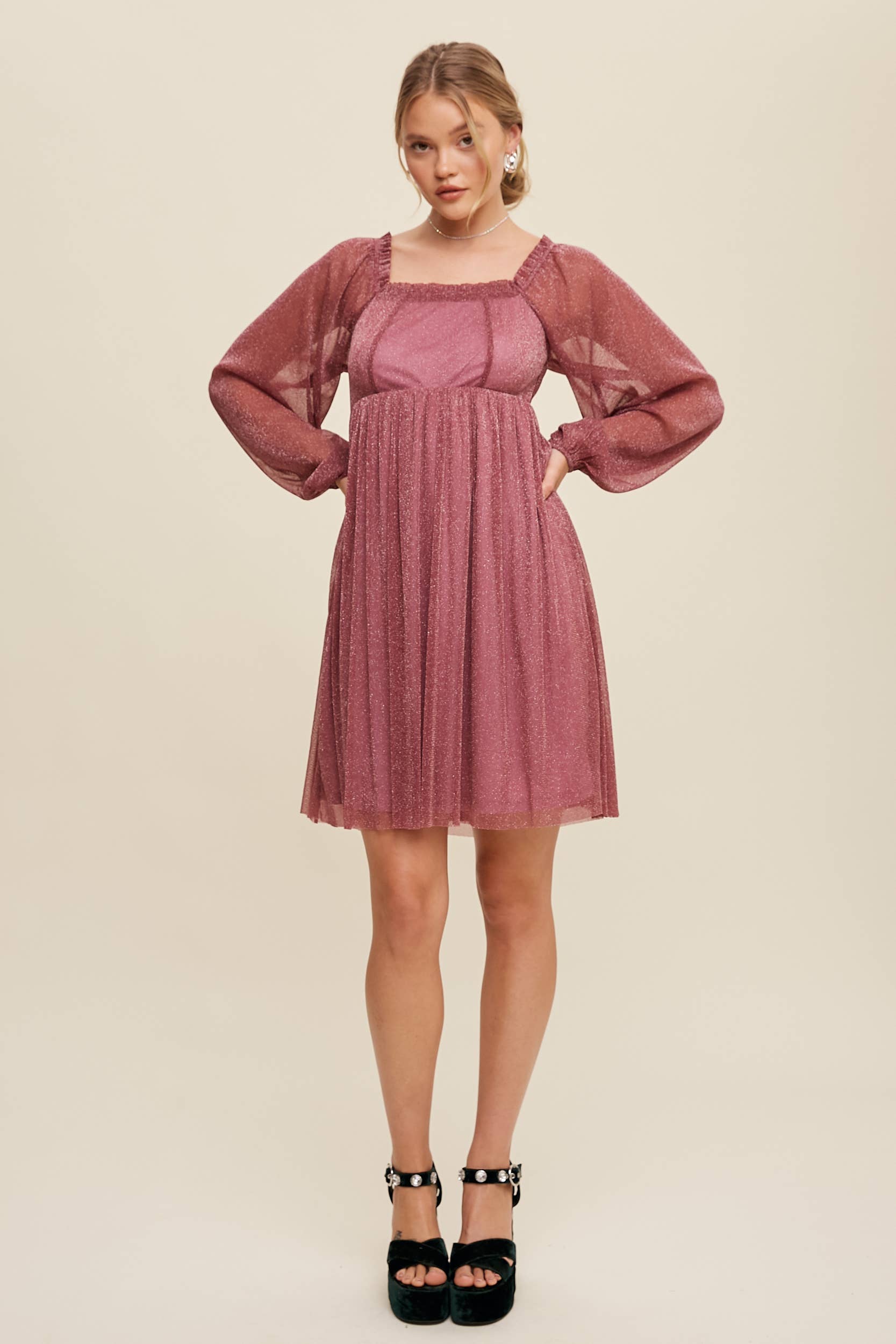 Model wearing a mauve shimmer mini dress with long sheer sleeves, square neckline, and flowy A-line silhouette — romantic sparkle party dress