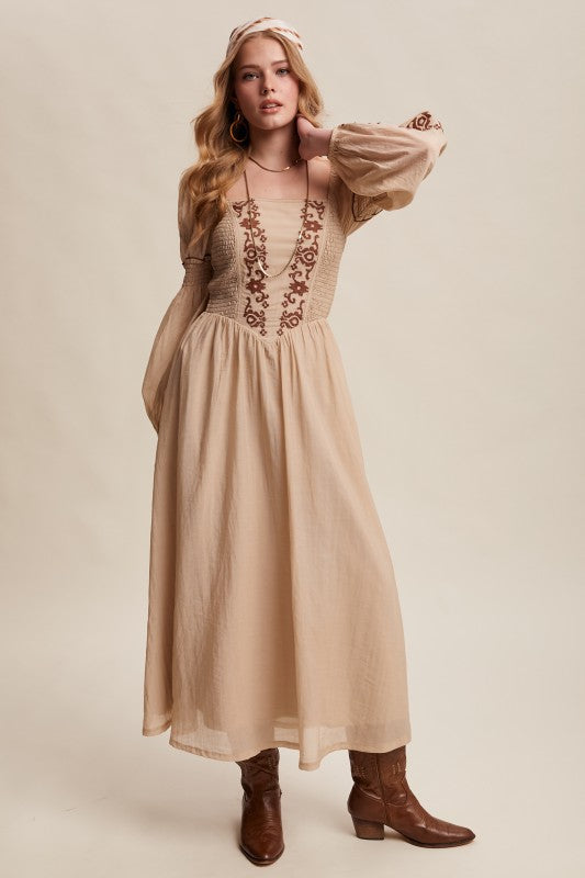 Beige long-sleeve boho maxi dress with puff sleeves and embroidered bodice.