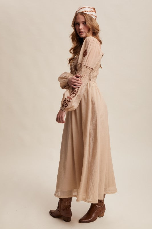 Side view of beige boho maxi dress with embroidered sleeves and smocked bodice.