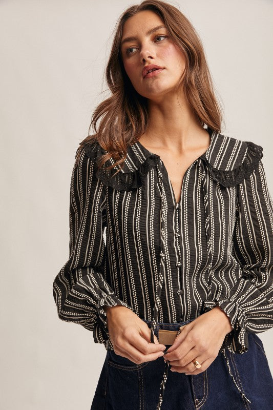 Black vertical-striped long-sleeve blouse with lace ruffle collar and button front.