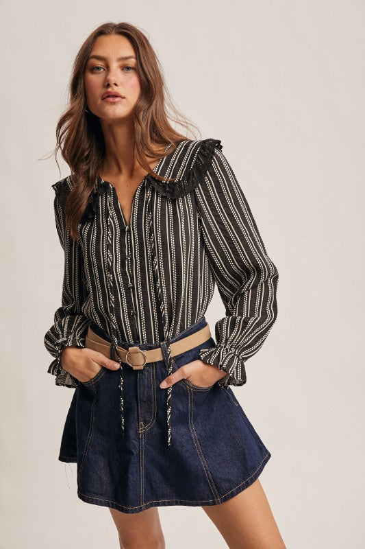 Black vertical-striped long-sleeve blouse with lace ruffle collar and button front.
