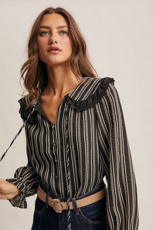 Black vertical-striped long-sleeve blouse with lace ruffle collar and button front.