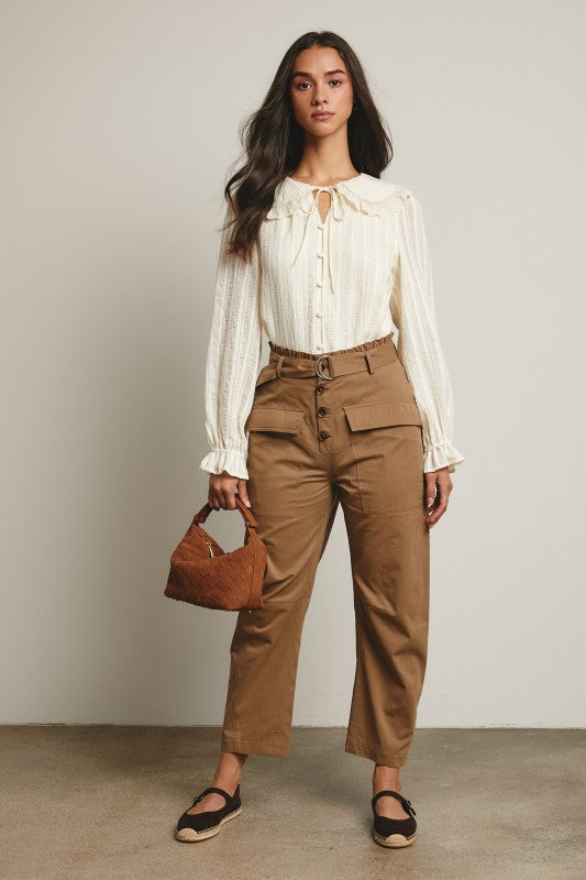 Ivory tie-neck blouse with ruffled Peter Pan collar, covered buttons, textured stripe fabric, and long puff sleeves.
