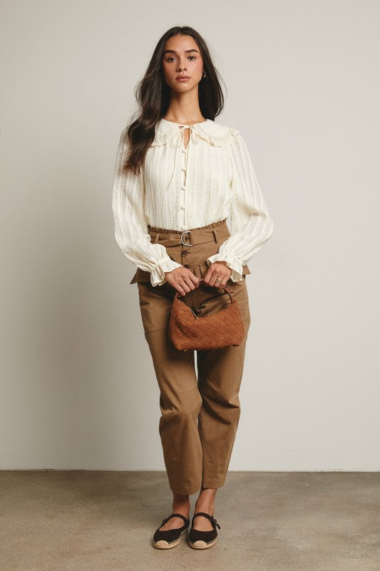 Ivory tie-neck blouse with ruffled Peter Pan collar, covered buttons, textured stripe fabric, and long puff sleeves.
