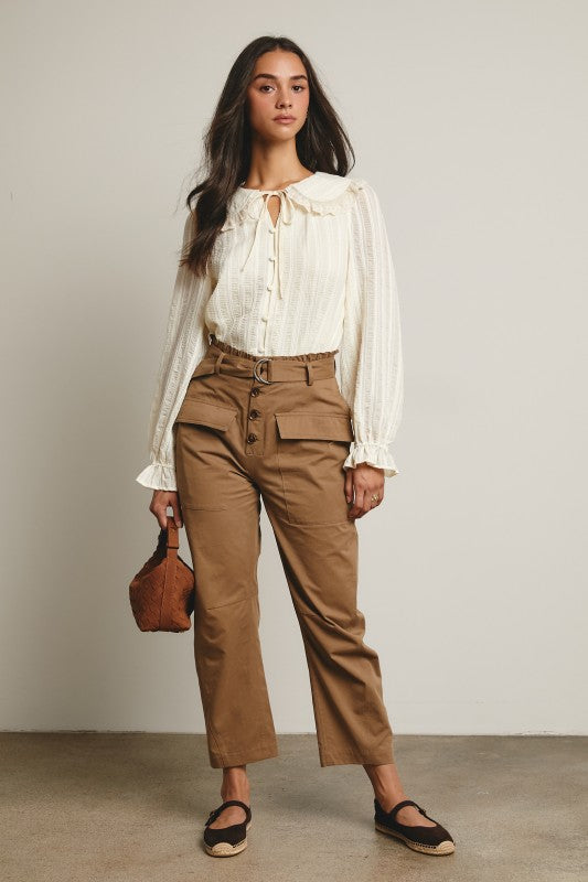 Ivory tie-neck blouse with ruffled Peter Pan collar, covered buttons, textured stripe fabric, and long puff sleeves.