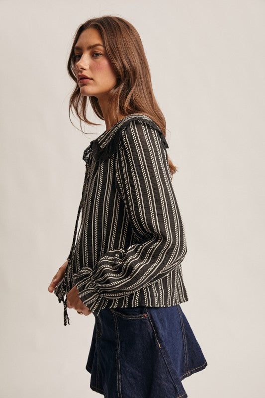 Black vertical-striped long-sleeve blouse with lace ruffle collar and button front.