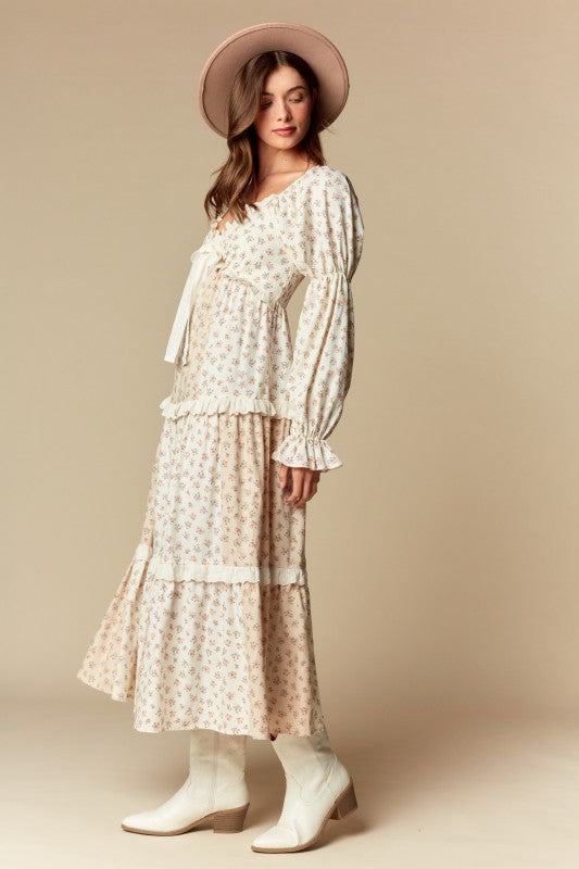 Side view — cream/blush ditsy floral tiered maxi dress with ruffle trim, long puff sleeves, tie-front sweetheart neckline.
