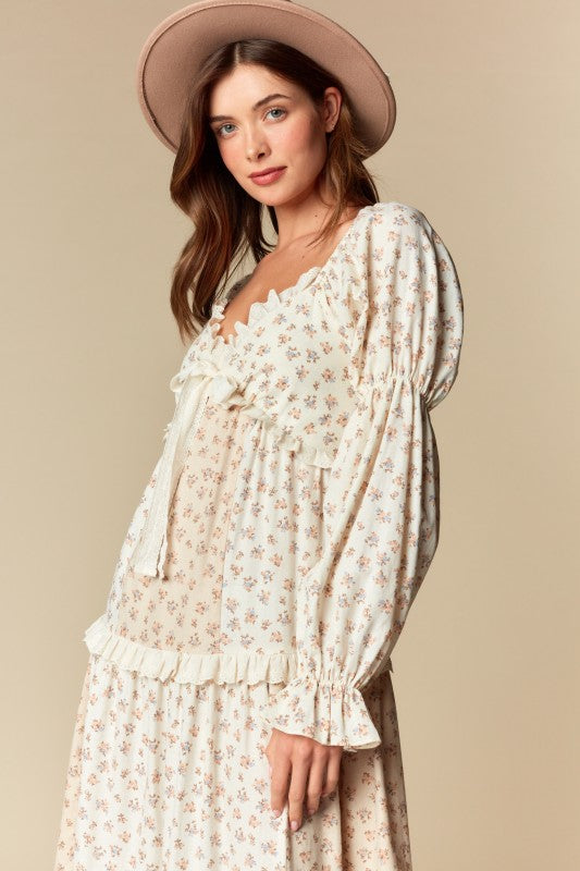 Side view — cream/blush ditsy floral tiered maxi dress with ruffle trim, long puff sleeves, tie-front sweetheart neckline.