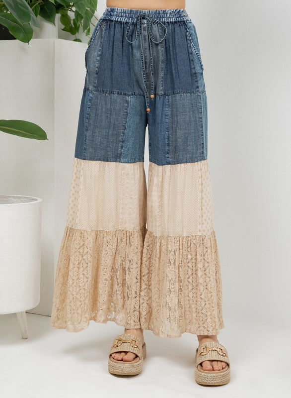 The Indigo & Lace Tiered Patchwork Pants - close-up of multi-tiered patchwork with denim, knit, and lace panels