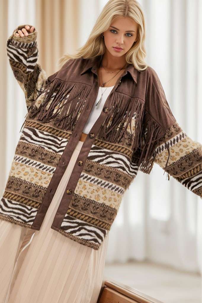Brown Aztec print shacket with fringe detailing, button-front closure, and long sleeves, styled over a white strapless top and cream pleated pants.