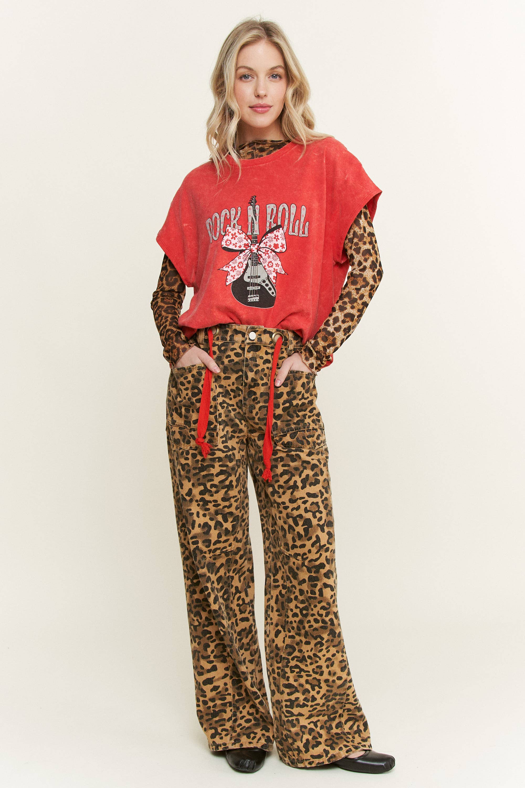 Person wearing a red 'Rock & Roll' mineral wash tee shirt and leopard print pants on a