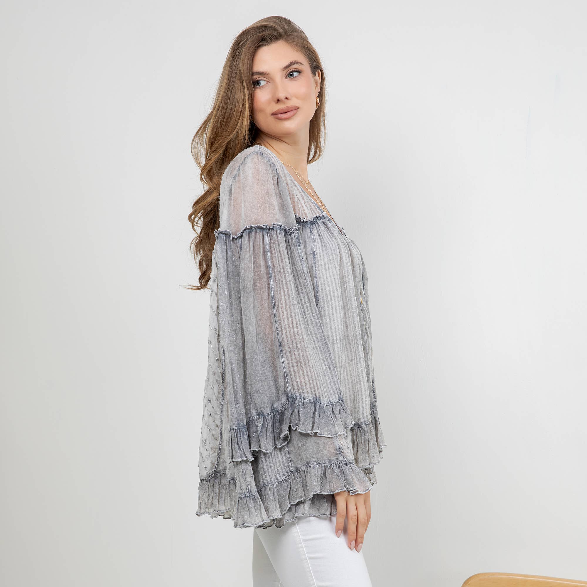 The Reverie Sheer Ruffled Blouse in Grey - side angle showing hip-length and relaxed fit