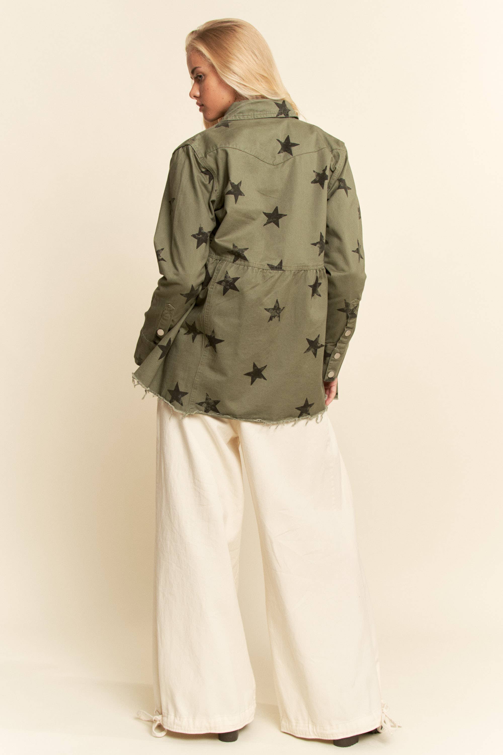 Back view- Olive star-print babydoll shacket with snap-button front, chest flap pockets, dropped shoulders, relaxed fit, and frayed curved hem.