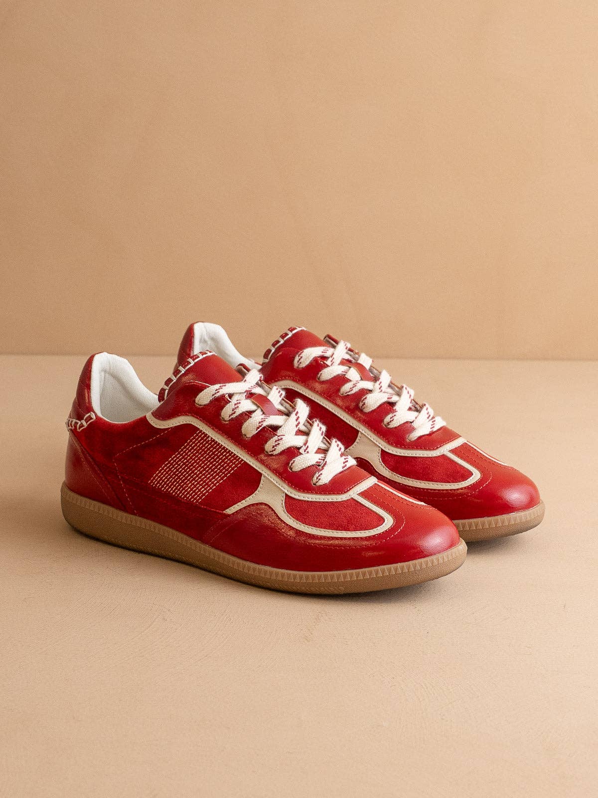 Cherry red Oasis Society sneakers with cream detailing and two lace options — organza ribbon and classic cotton.