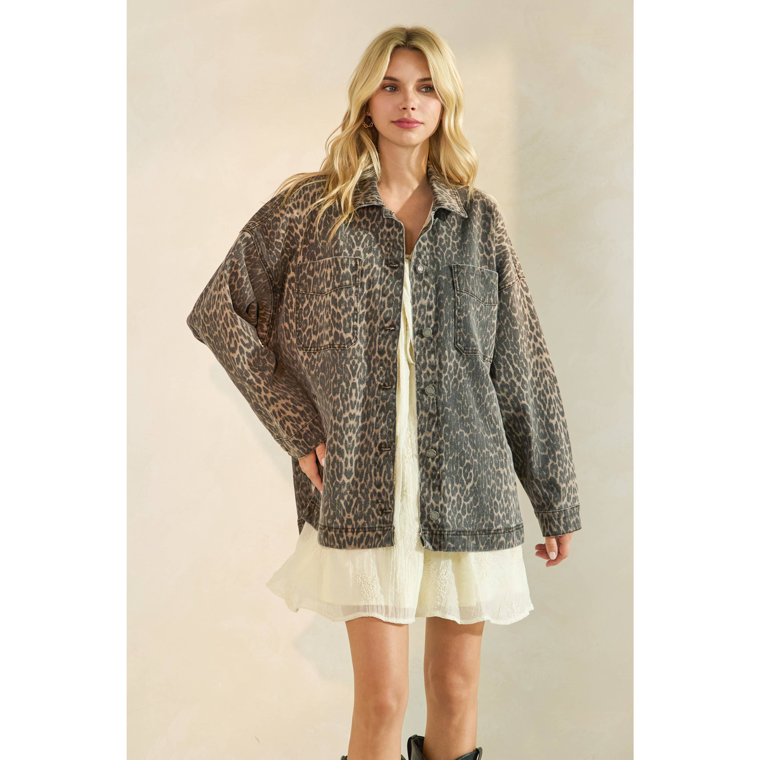Oversized camouflage print jacket with front pockets and button closure, styled over a white tiered mini dress.