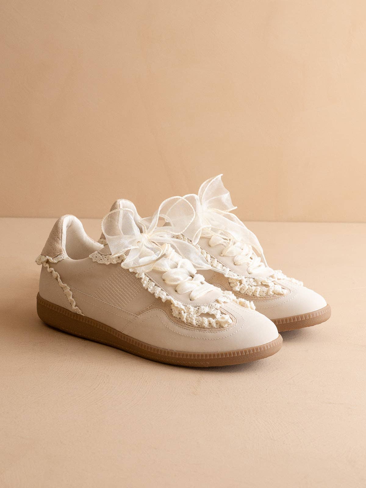 Women’s ivory low-top sneaker with crochet lace trim and gum rubber sole, side view.