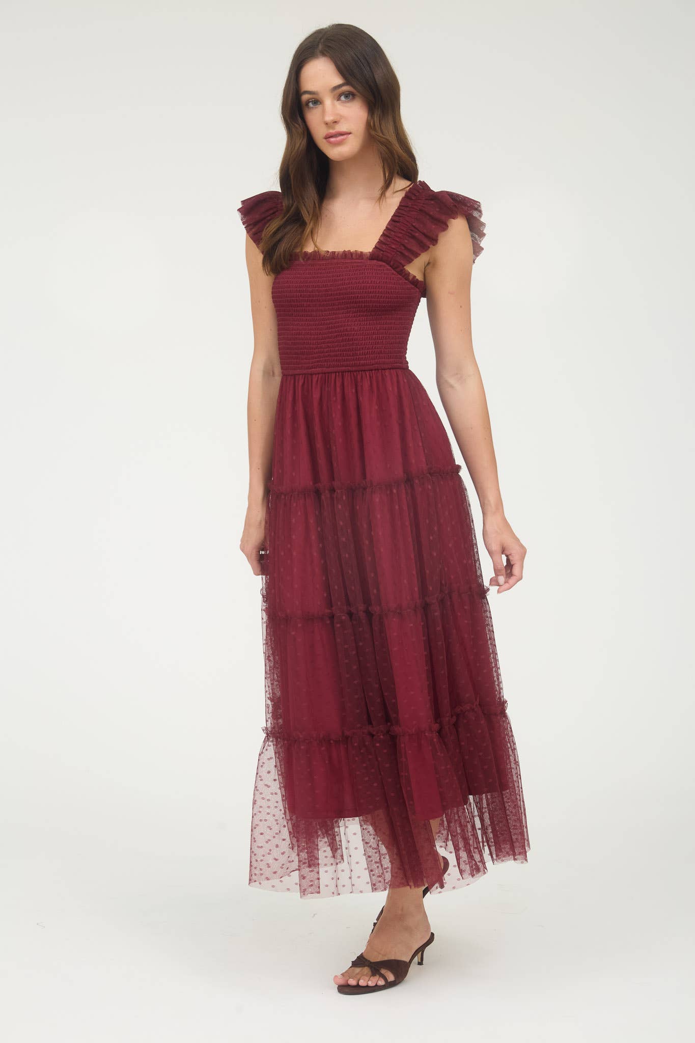 Model wearing burgundy smocked midi dress with ruffle sleeves, tiered dotted mesh overlay, and flowy A-line silhouette.