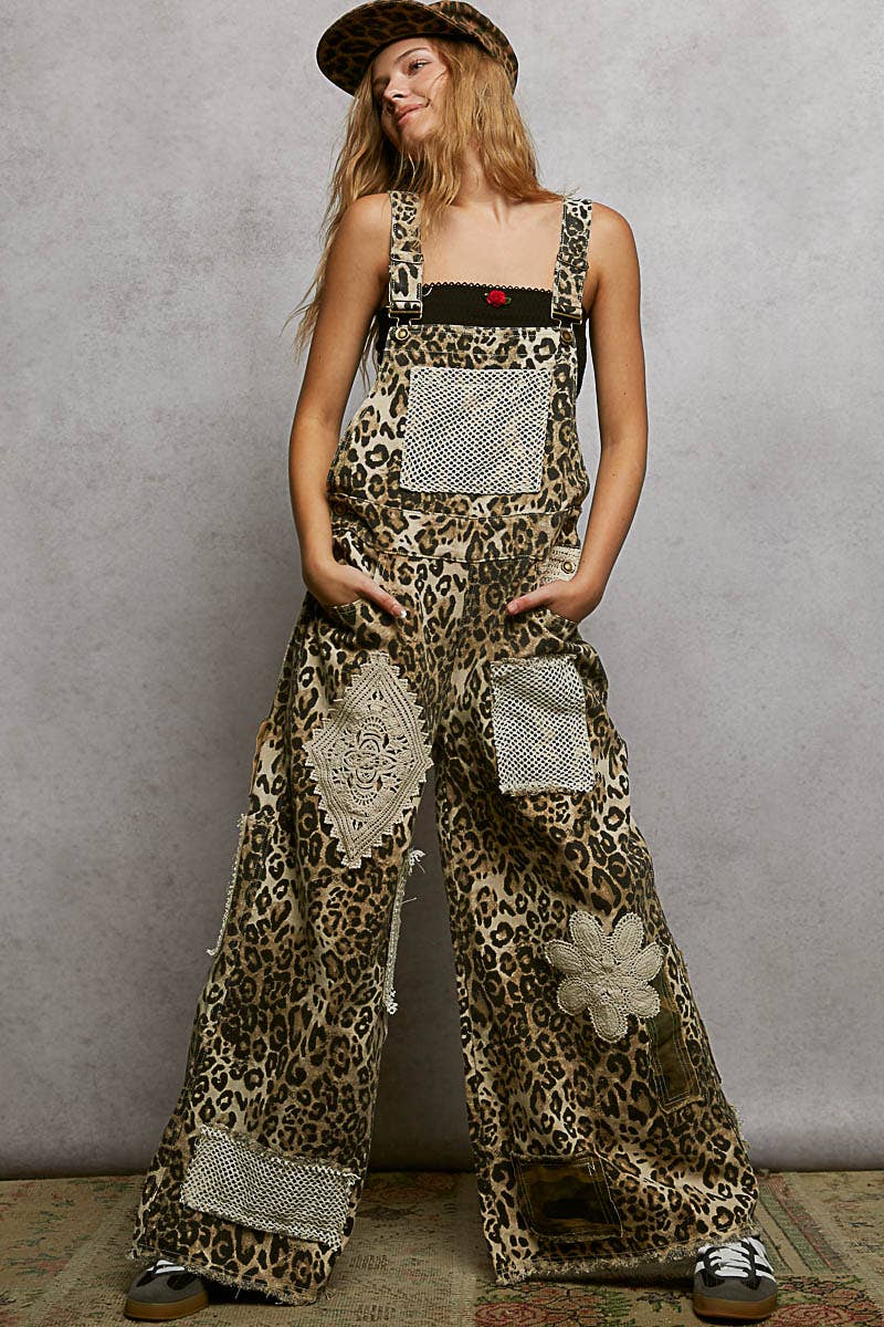 Boho leopard print patchwork overalls featuring wide legs, crochet lace appliqué details, and distressed accents. Styled with a leopard hat and black crop top for a trendy, eclectic look.