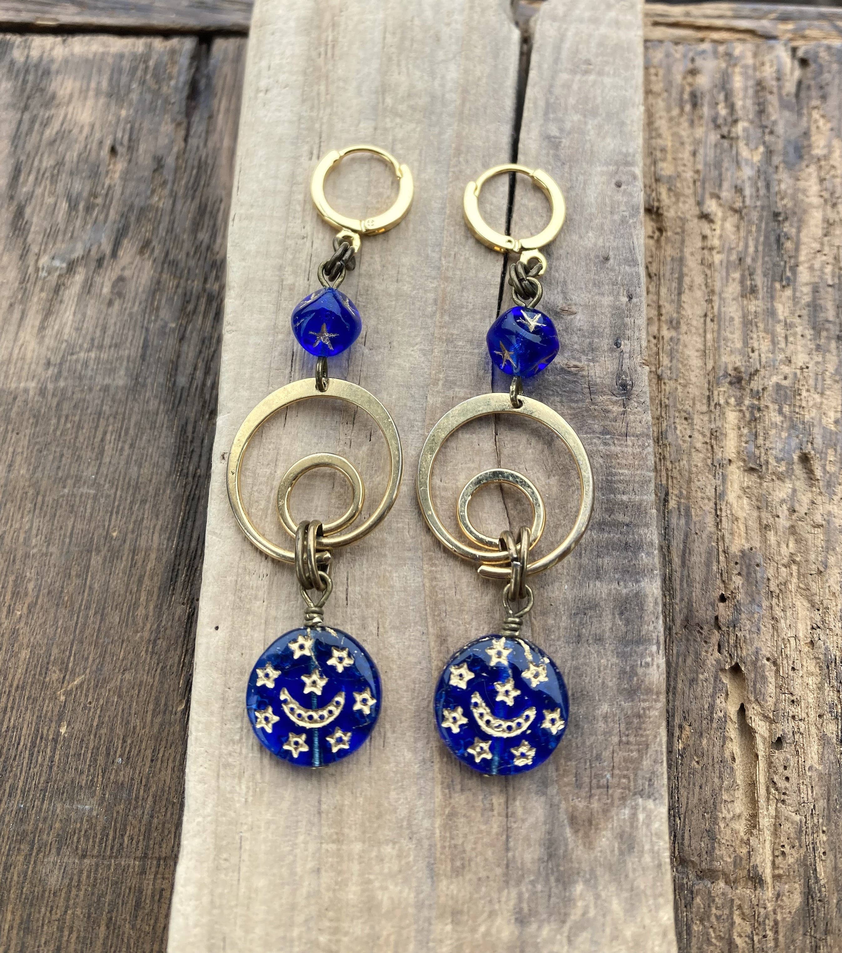 Artisan dangle earrings featuring gold rings, blue glass beads, and night sky charms.