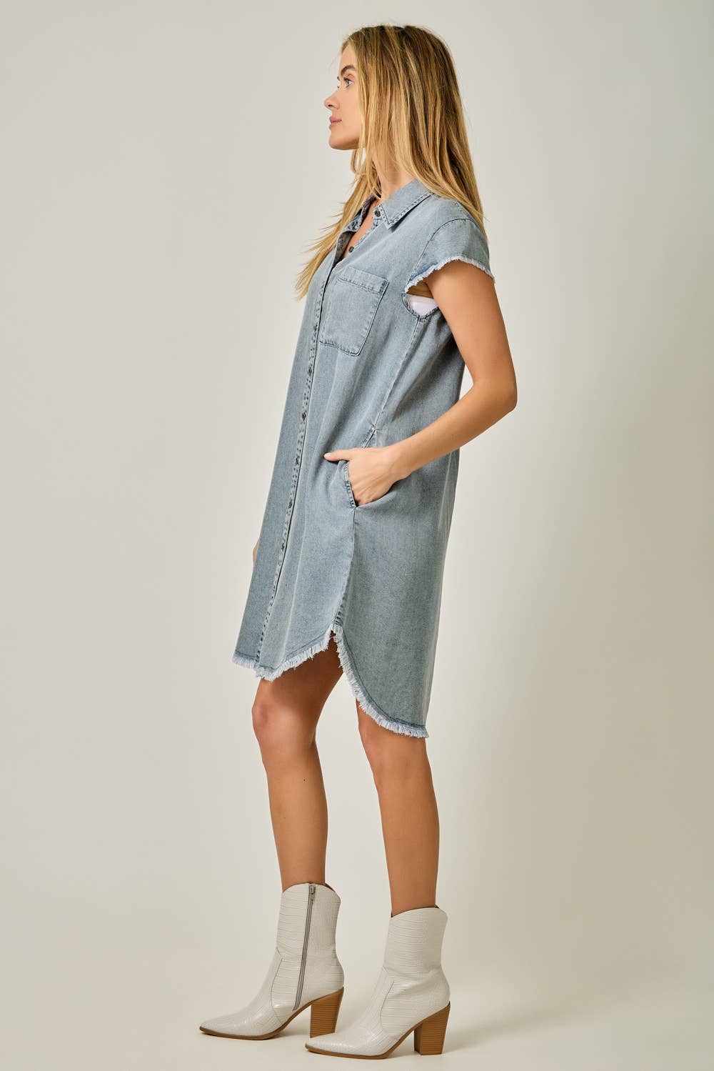 Side view Fringe Hem Tencel Shirt Dress in Light Denim Blue — button-down front, flutter cap sleeves, fringed hi-lo hem, and side pockets