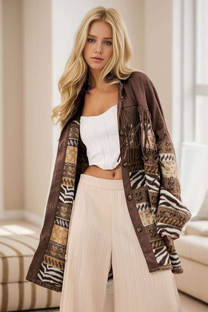 Brown Aztec print shacket with fringe detailing, button-front closure, and long sleeves, styled over a white strapless top and cream pleated pants.