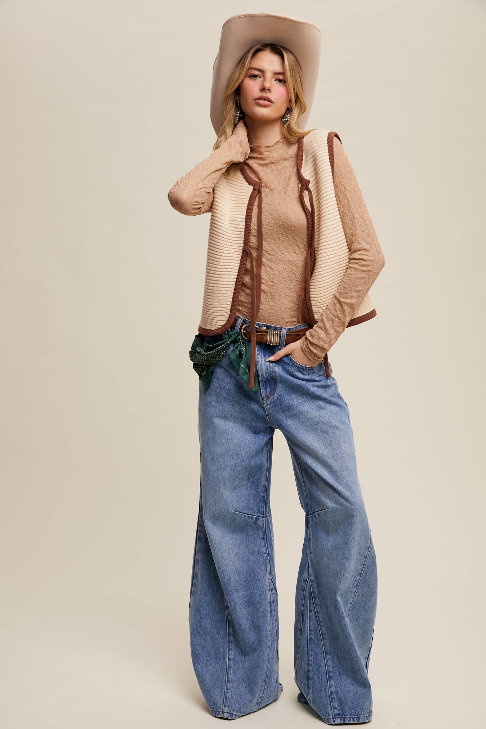 High-rise light-wash wide-leg jeans with front seam panels and knee darts, five-pocket style with zip fly, styled with tan long-sleeve top and pointed-toe boots.