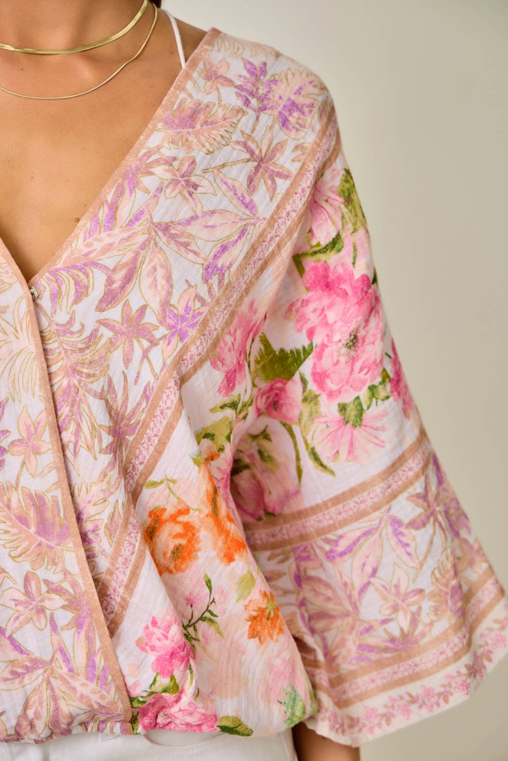 Floral patterned garment with pink and orange flowers on a neutral background