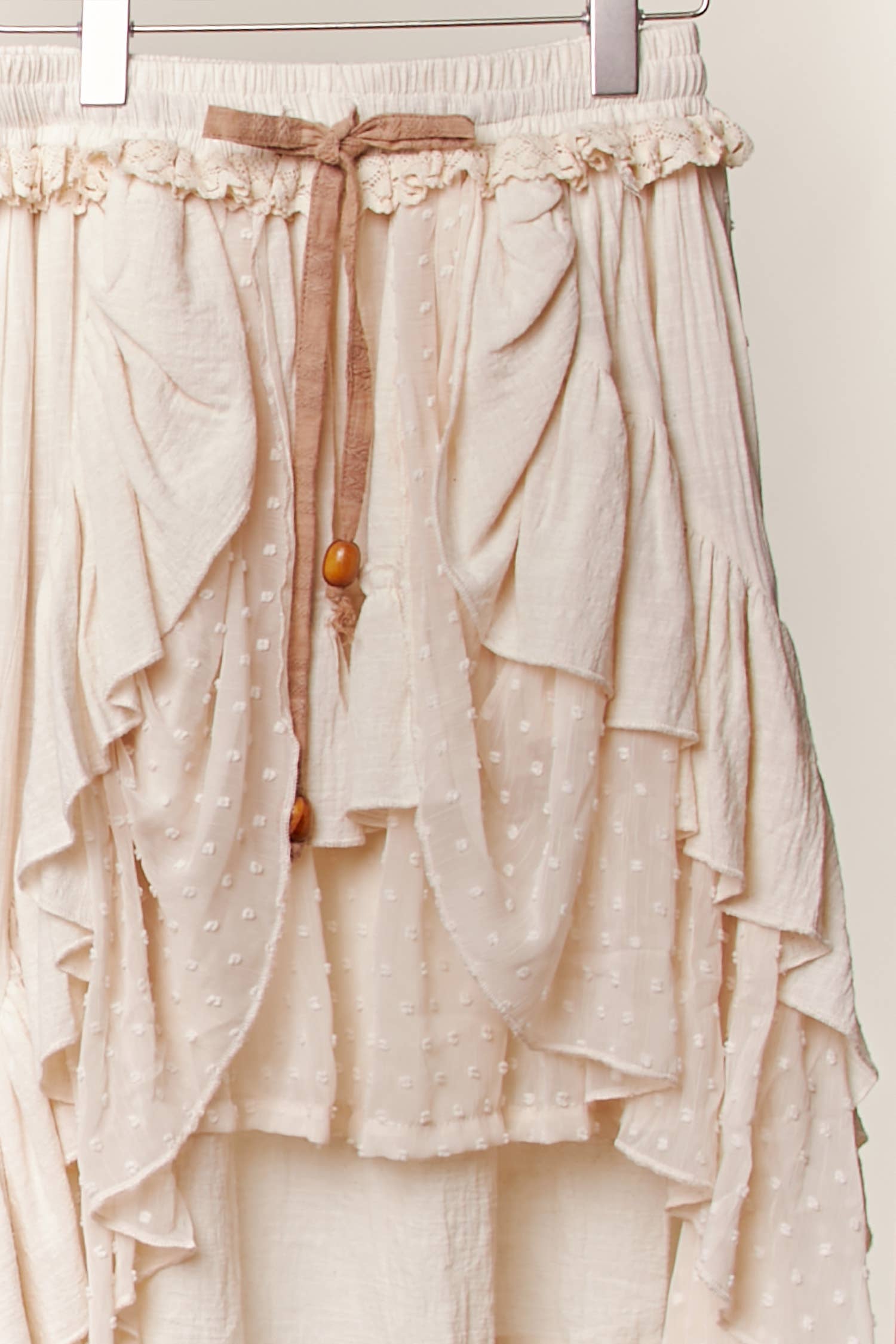 Ivory tiered skirt side angle - flowing high-low maxi with wooden bead accents and romantic ruffle layers