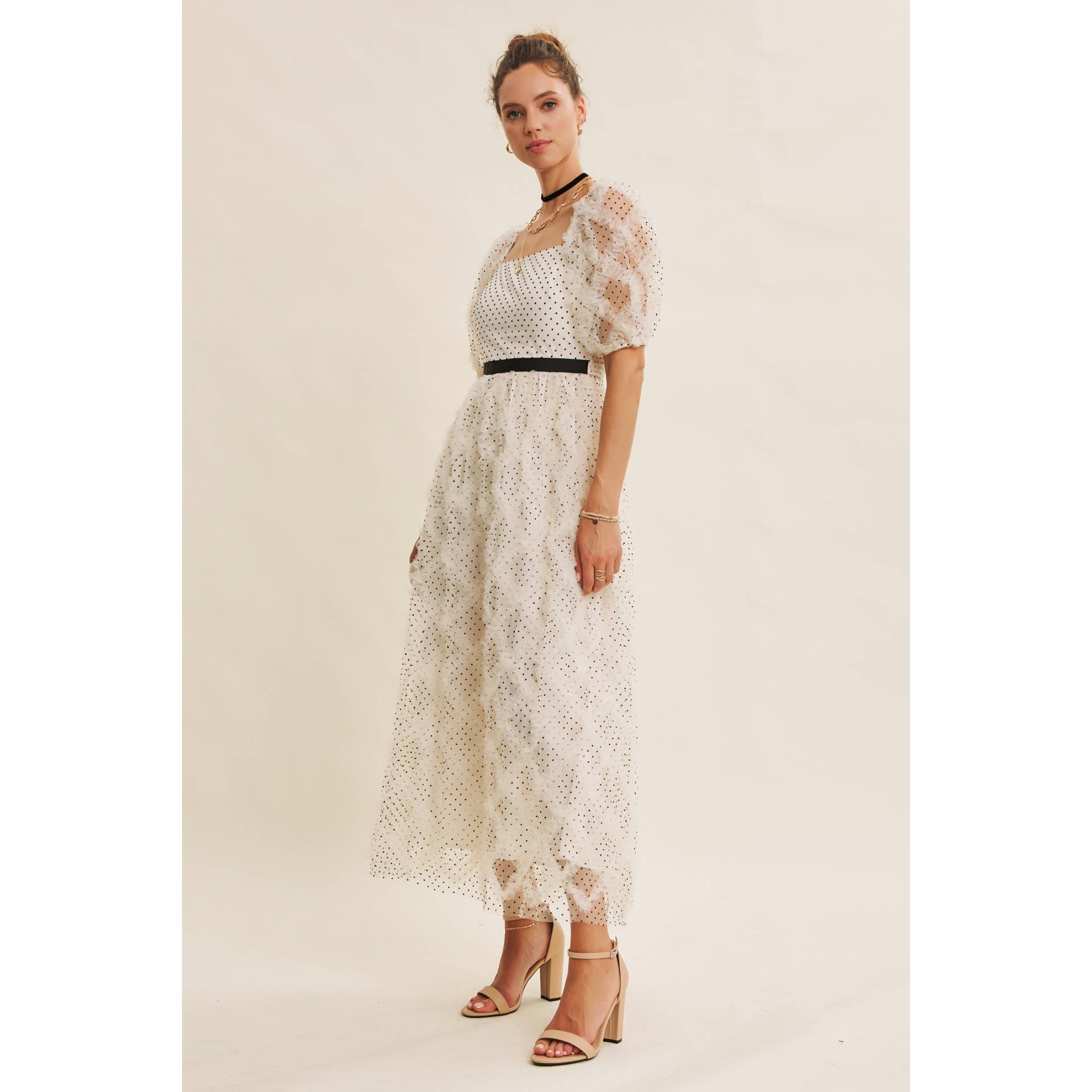 Three-quarter view — cream polka-dot tulle midi dress with puff sleeves, square neckline, black waist belt, side angle on model.