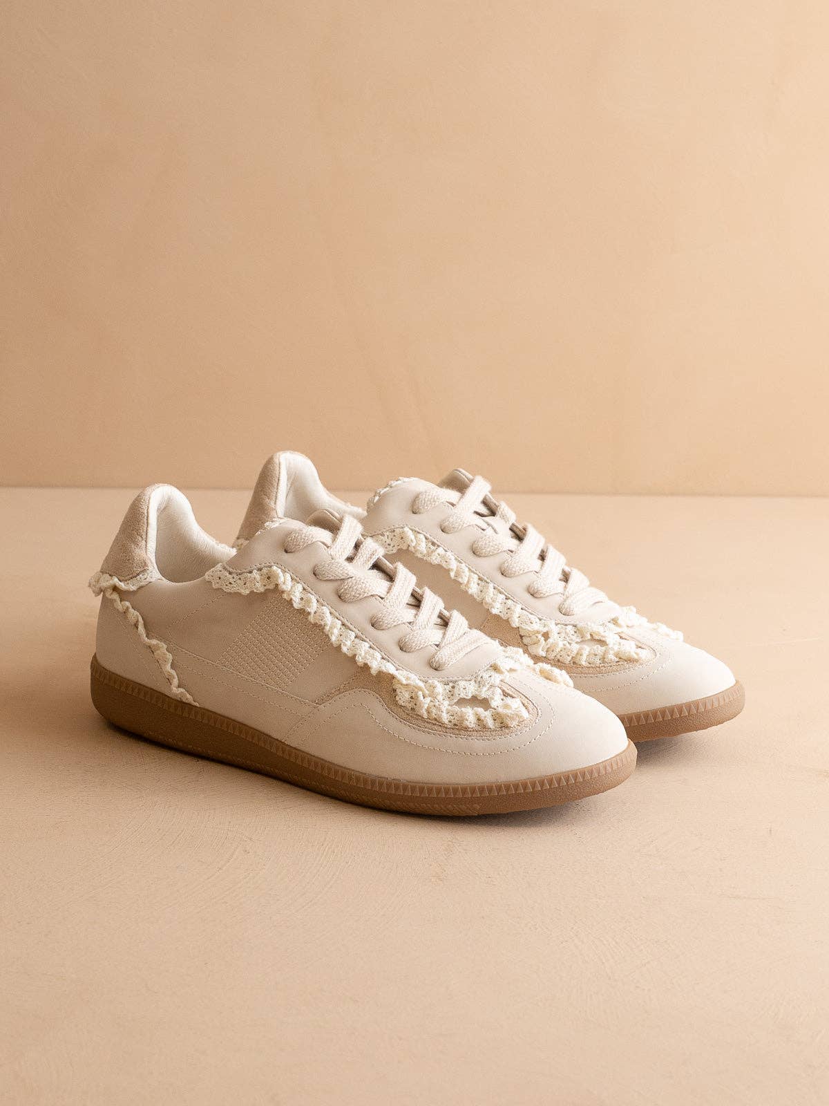 Women’s ivory low-top sneaker with crochet lace trim and gum rubber sole, side view.