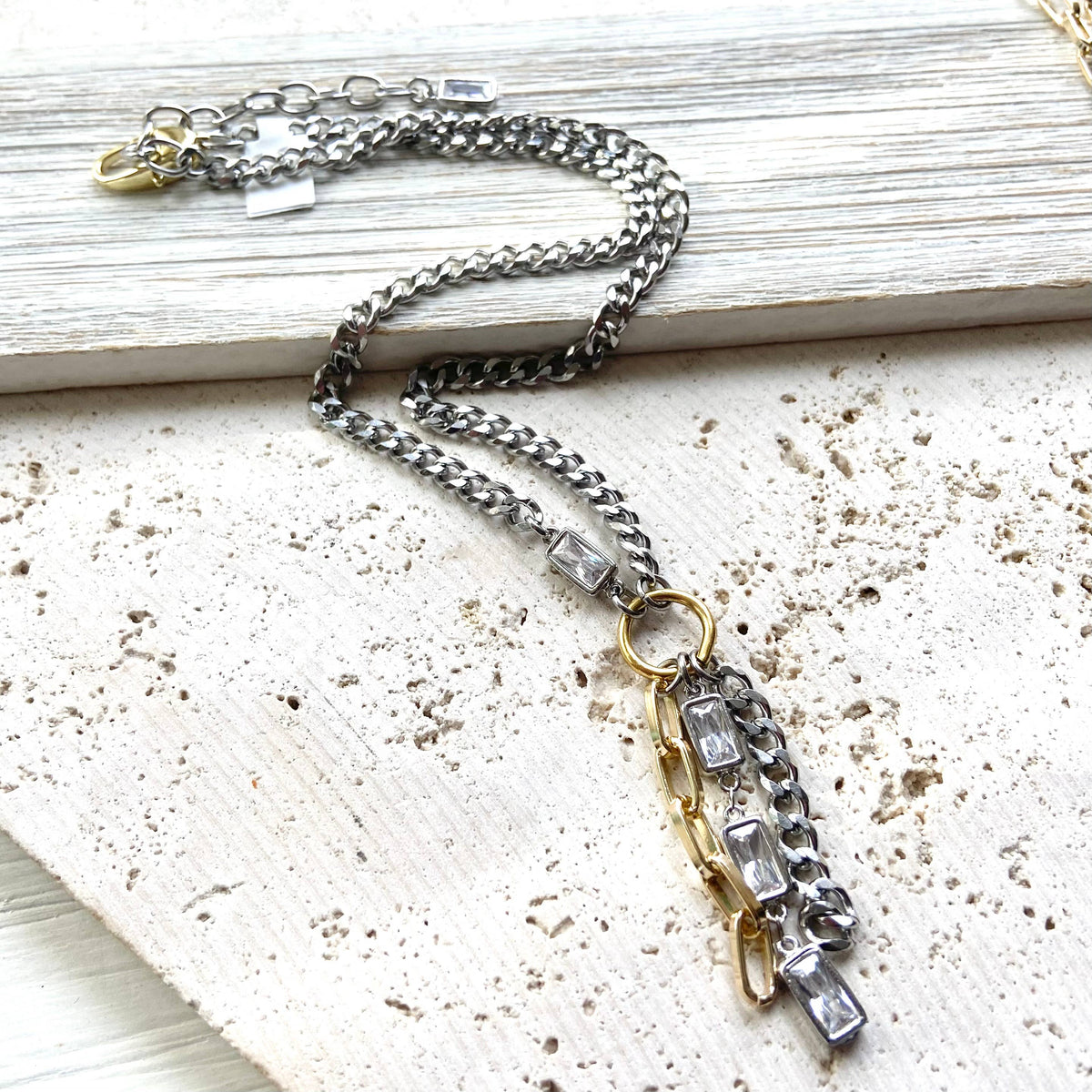 Necklace with chain and pendant on a textured surface