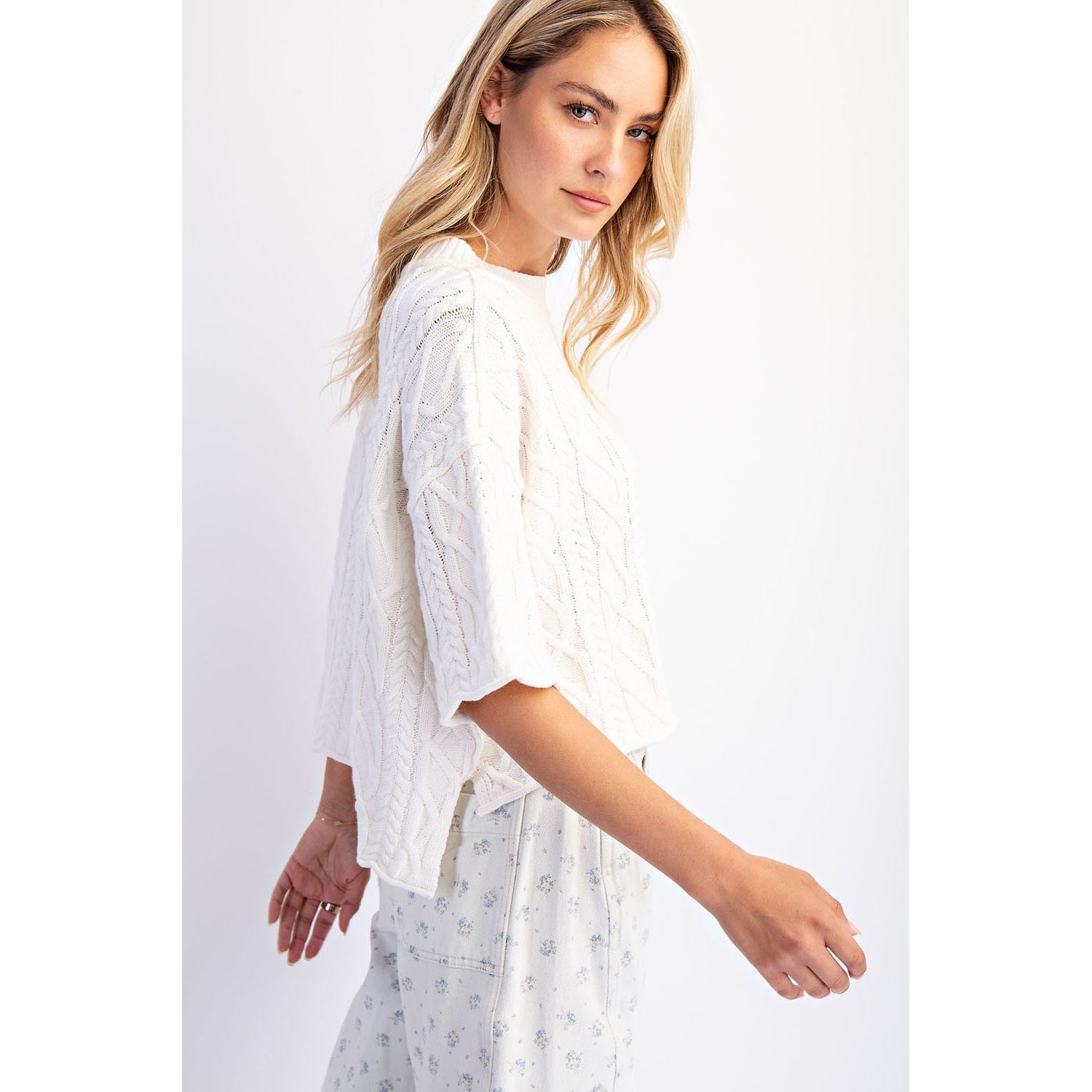 Side view of The Cove Oversized Sweater in Off White — front view, slouchy cable knit with dropped shoulders and asymmetrical hem in off white