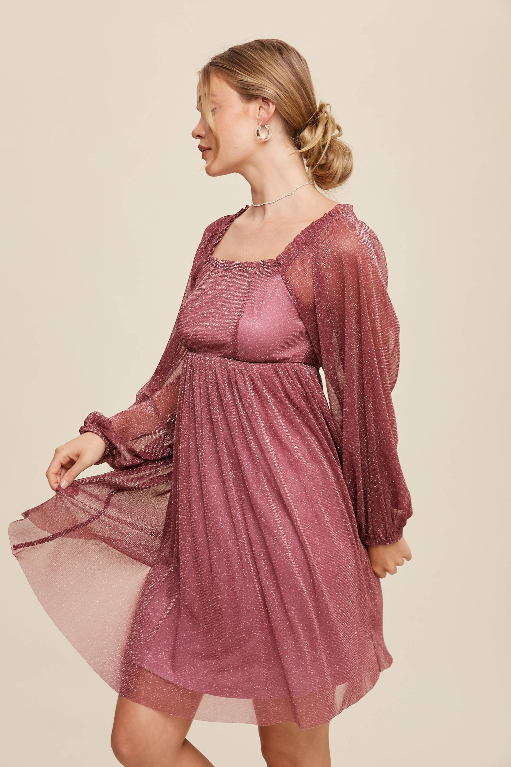 Model wearing a mauve shimmer mini dress with long sheer sleeves, square neckline, and flowy A-line silhouette — romantic sparkle party dress