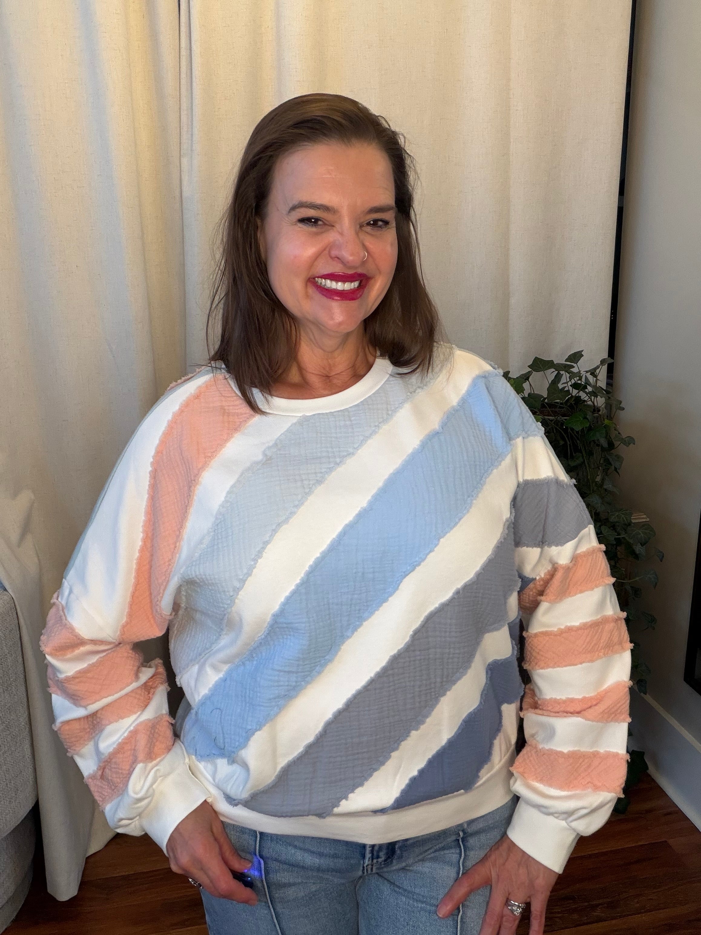 Woman wearing a colorful striped sweater in a home setting