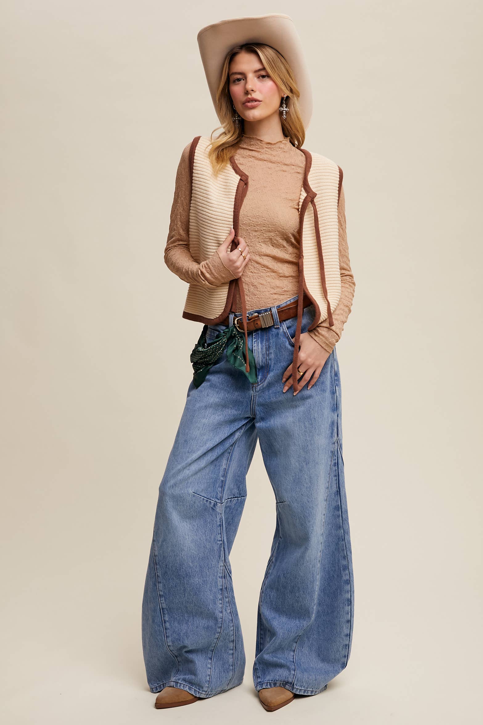 High-rise light-wash wide-leg jeans with front seam panels and knee darts, five-pocket style with zip fly, styled with tan long-sleeve top and pointed-toe boots.