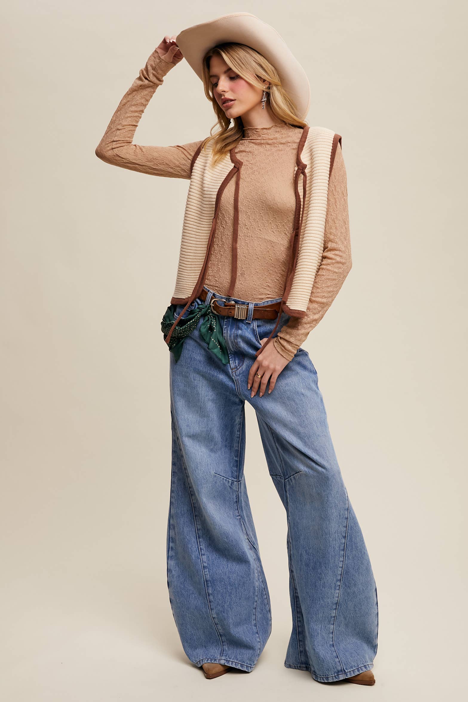High-rise light-wash wide-leg jeans with front seam panels and knee darts, five-pocket style with zip fly, styled with tan long-sleeve top and pointed-toe boots.