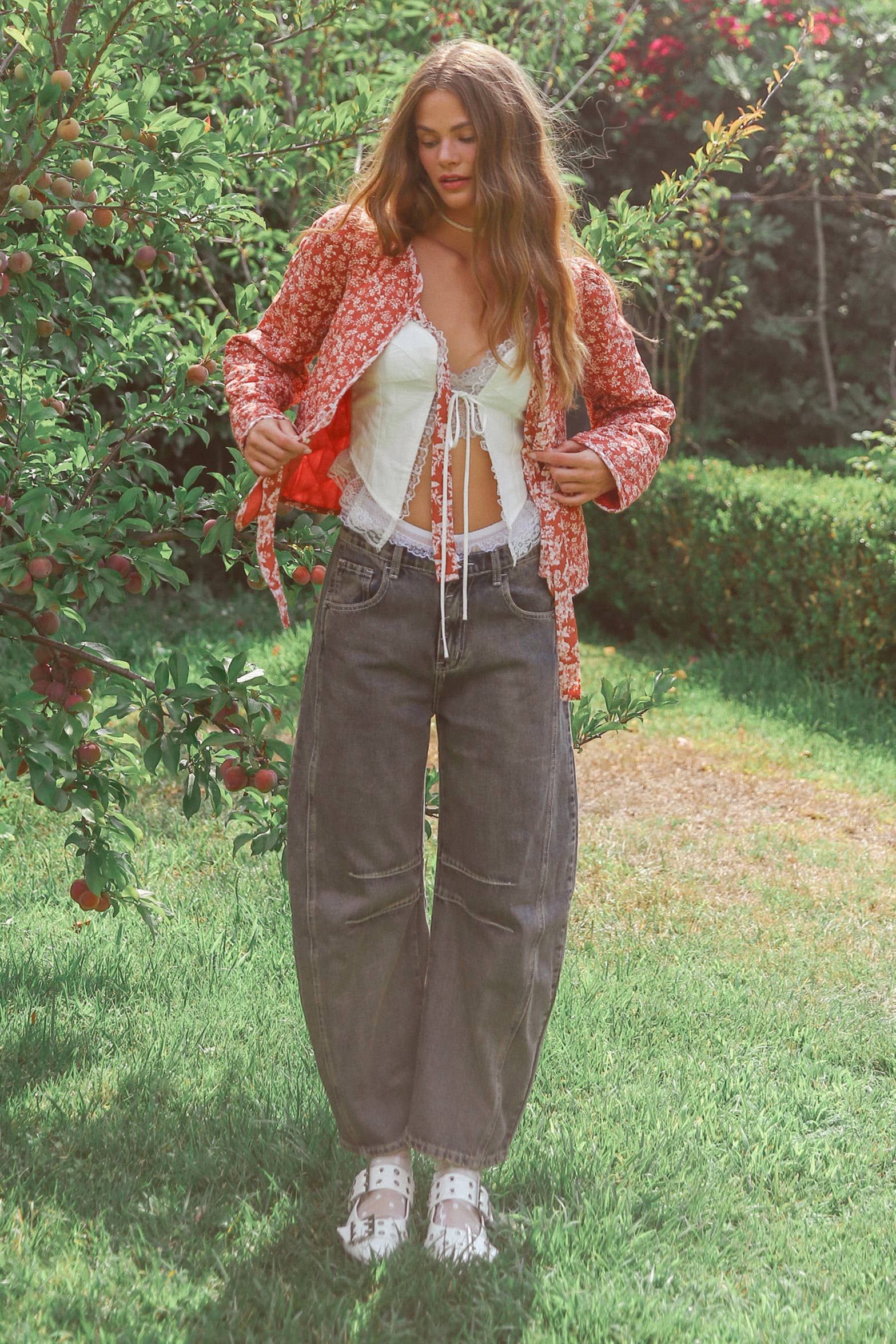 Dark wash wide-leg jeans with relaxed fit, seam detailing across the knees, and a high-rise waist, styled with brown ankle boots.