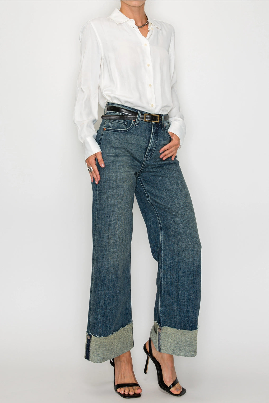 Front view — dark-wash high-rise wide-leg jeans with extra-wide cuffed hems and raw edge, 5-pocket style on model.