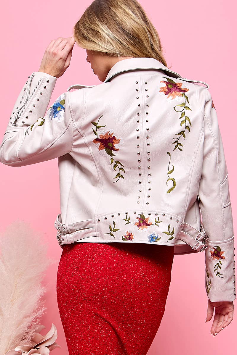 Back view of cream faux-leather moto jacket with floral embroidery and stud trim, worn over a red dress.