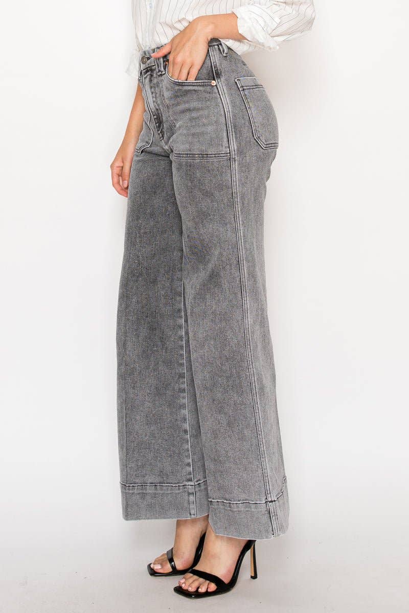 Person wearing gray wide-leg jeans on a white background