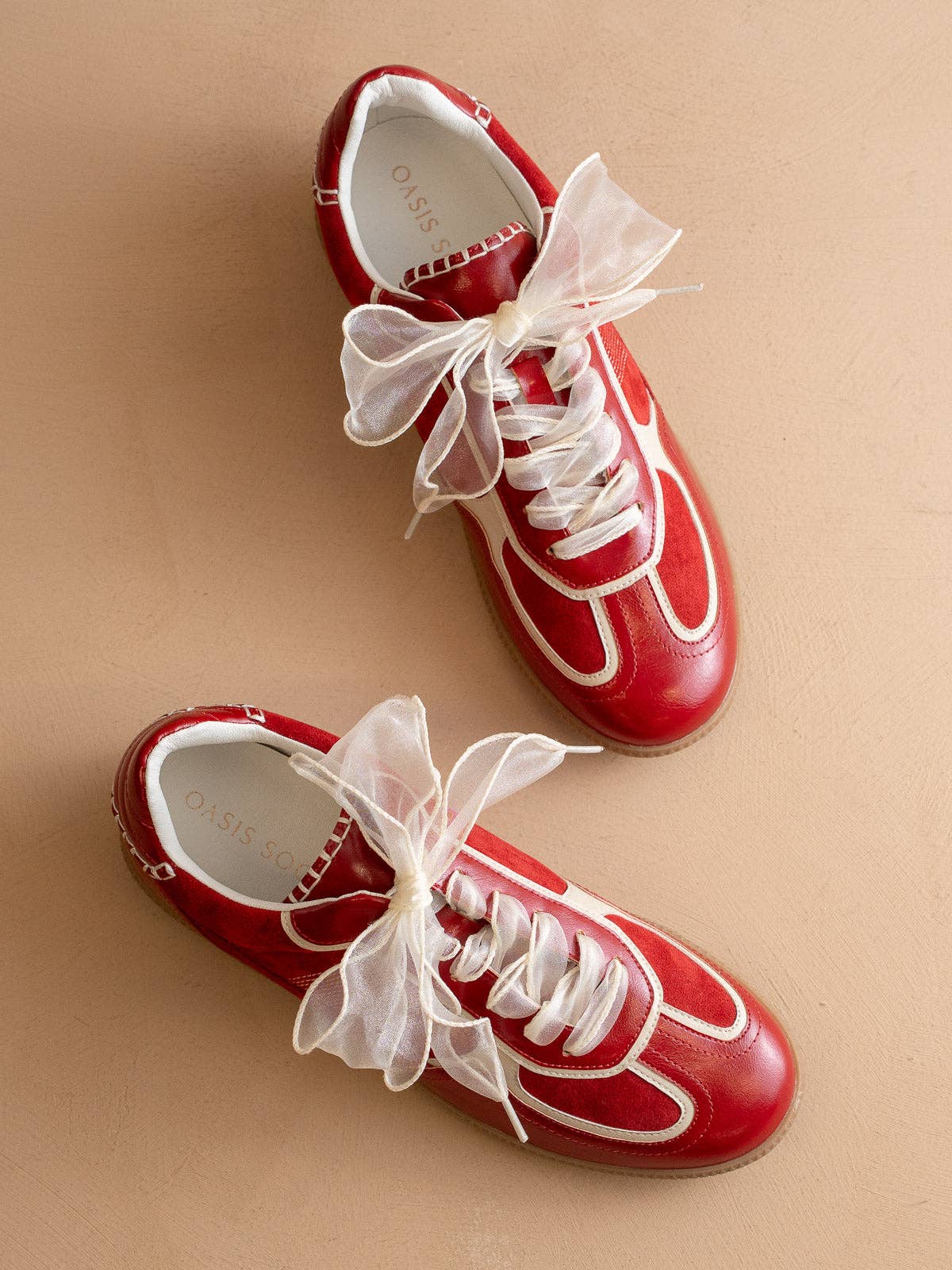 Cherry red Oasis Society sneakers with cream detailing and two lace options — organza ribbon and classic cotton.